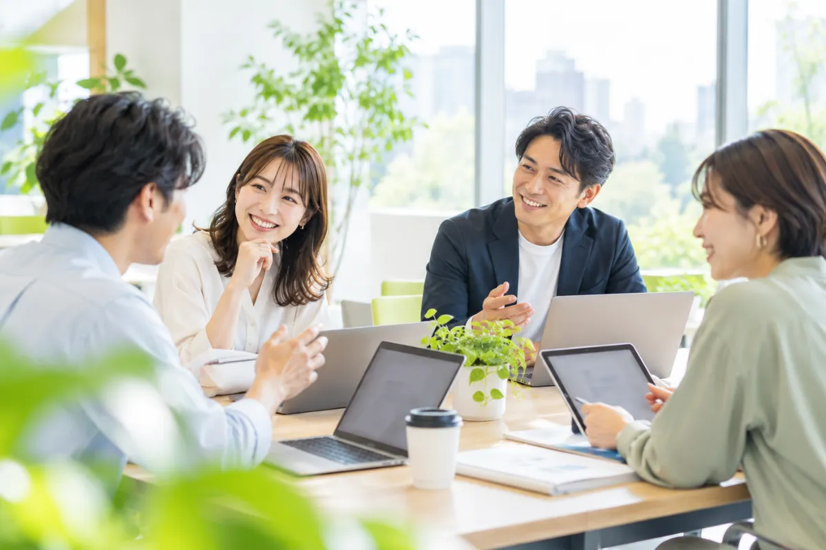採用支援会社のチームがノートパソコンを囲んで打ち合わせをしている